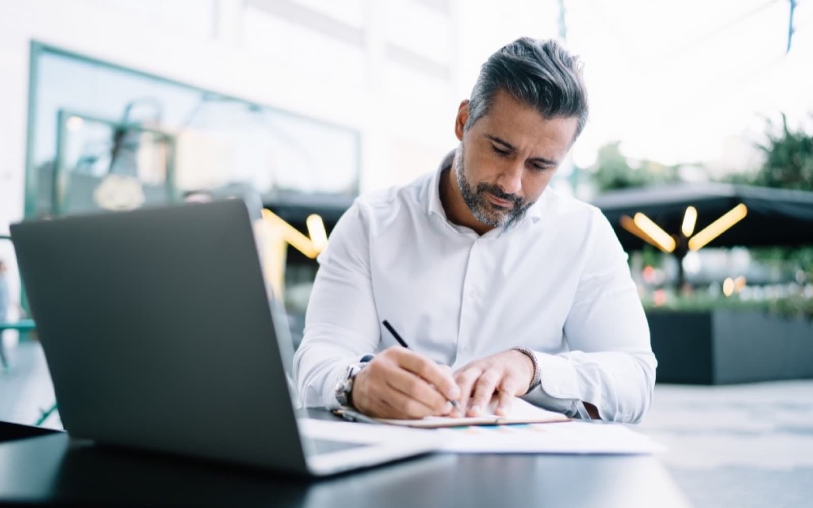 A business owner reviewing documents at an outdoor table.